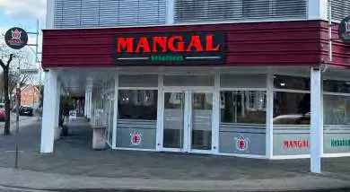 Außenansicht des Mangal Kebabhaus mit rotem Schriftzug über der Fensterfront